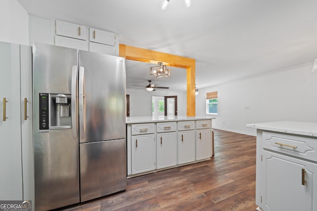 kitchen featuring stainless steel refrigerator with ice dispenser, ceiling fan with notable chandelier, a peninsula, dark wood-style floors, and white cabinetry