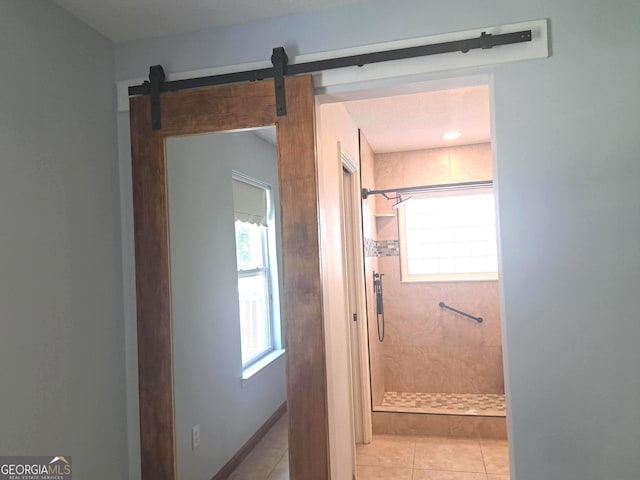 full bath featuring a tile shower and tile patterned flooring