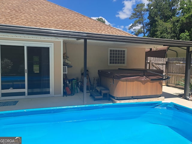 view of pool with a patio, a hot tub, fence, and a covered pool