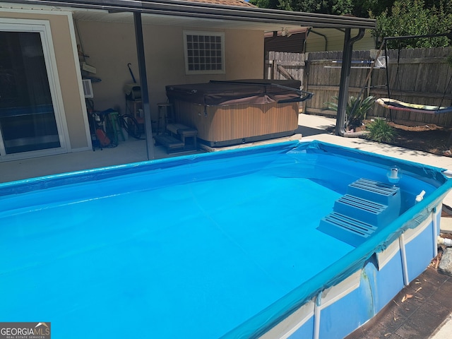 view of pool featuring a fenced in pool, a hot tub, and fence
