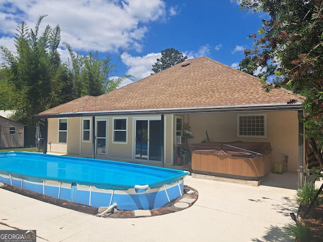 pool featuring a hot tub and a patio