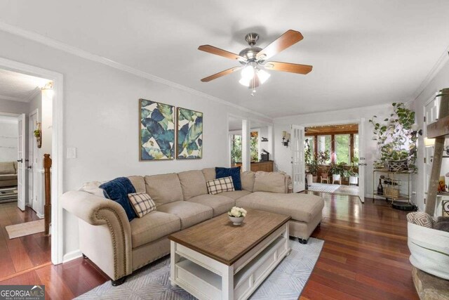 living area featuring baseboards, ornamental molding, ceiling fan, and wood finished floors