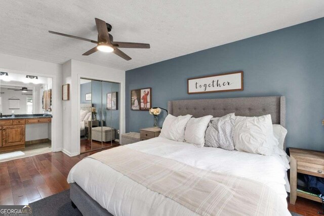 bedroom with a closet, hardwood / wood-style floors, ceiling fan, a textured ceiling, and ensuite bath