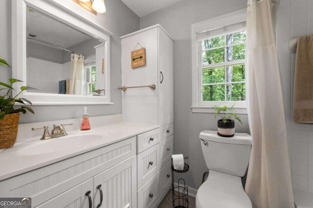 bathroom with vanity, plenty of natural light, a shower with curtain, and toilet