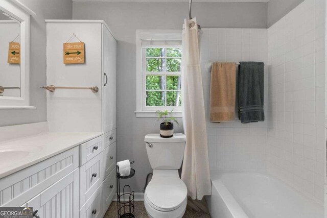 bathroom with toilet, shower / tub combo with curtain, and vanity