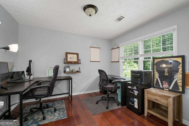 office space featuring baseboards, a textured ceiling, visible vents, and wood finished floors