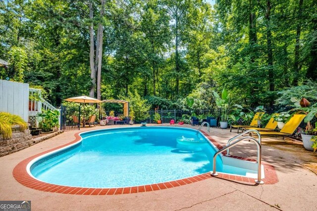 view of swimming pool with a patio, a fenced in pool, and fence