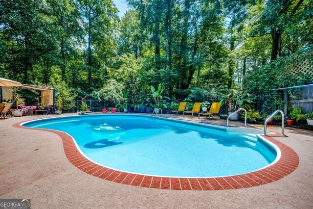 view of swimming pool featuring a fenced in pool, a fenced backyard, and a patio