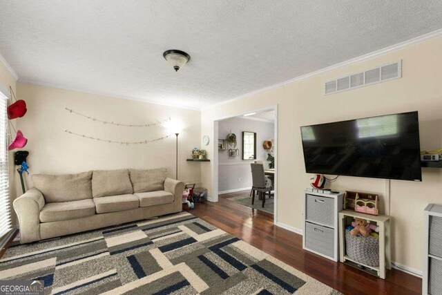living room featuring crown molding, a textured ceiling, wood finished floors, and visible vents
