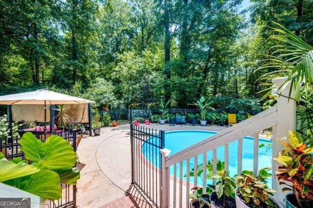 community pool featuring fence and a patio area