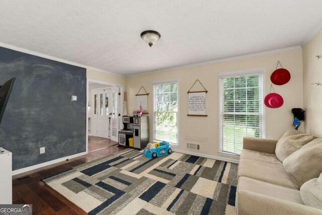 living room with baseboards, visible vents, a wealth of natural light, and wood finished floors