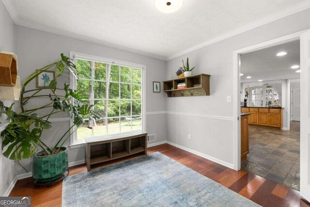 sitting room with crown molding, baseboards, and visible vents