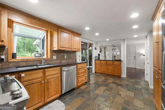 kitchen with a healthy amount of sunlight, tasteful backsplash, dishwasher, a sink, and recessed lighting