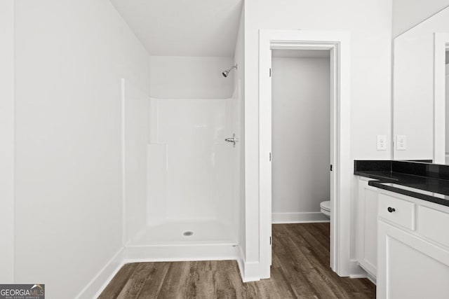 3261 Broadnax Mill Rd Unit 2, Loganville, GA 30052 - full bathroom featuring a shower, wood finished floors, baseboards, vanity, and toilet