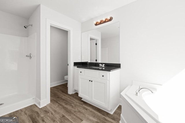 3261 Broadnax Mill Rd Unit 2, Loganville, GA 30052 - full bath featuring a garden tub, walk in shower, wood finished floors, vanity, and toilet