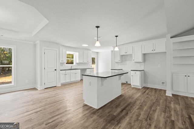 3261 Broadnax Mill Rd Unit 2, Loganville, GA 30052 - kitchen featuring white cabinets, wood finished floors, a kitchen island, and tasteful backsplash