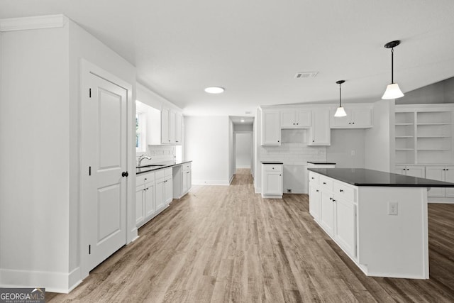 3261 Broadnax Mill Rd Unit 2, Loganville, GA 30052 - kitchen featuring a sink, baseboards, light wood-type flooring, backsplash, and visible vents