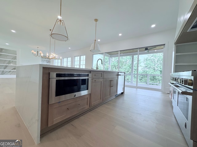 5753 Brendlynn Dr, Suwanee, GA 30024 - kitchen featuring white appliances, recessed lighting, a chandelier, light wood-style flooring, and a kitchen island with sink