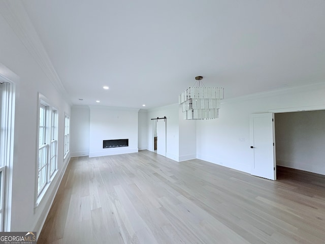 5753 Brendlynn Dr, Suwanee, GA 30024 - unfurnished living room featuring crown molding, a barn door, recessed lighting, and light wood finished floors