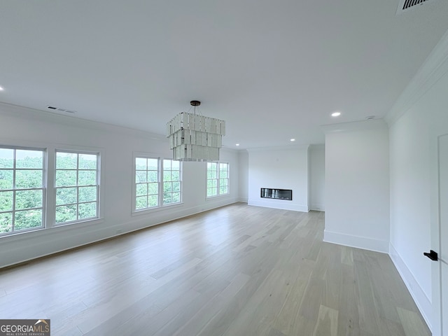 5753 Brendlynn Dr, Suwanee, GA 30024 - unfurnished living room with ornamental molding, light wood-type flooring, recessed lighting, and a glass covered fireplace