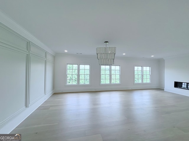 5753 Brendlynn Dr, Suwanee, GA 30024 - unfurnished living room featuring a chandelier, crown molding, light wood-style flooring, recessed lighting, and a fireplace