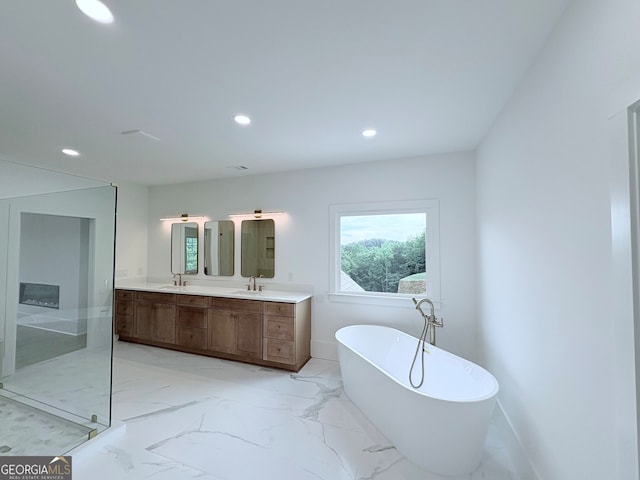 5753 Brendlynn Dr, Suwanee, GA 30024 - bathroom featuring a freestanding tub, double vanity, recessed lighting, marble finish flooring, and a shower