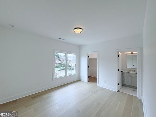 5753 Brendlynn Dr, Suwanee, GA 30024 - unfurnished bedroom featuring light wood finished floors, a spacious closet, and ensuite bath