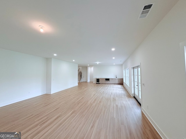 5753 Brendlynn Dr, Suwanee, GA 30024 - unfurnished living room with light wood finished floors, recessed lighting, stairs, and french doors