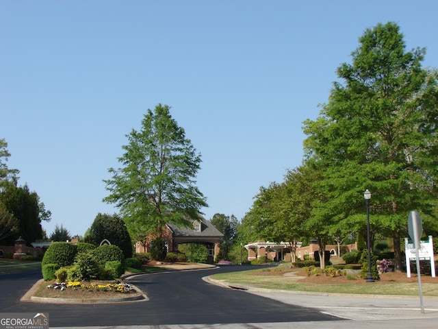 5753 Brendlynn Dr, Suwanee, GA 30024 - view of asphalt street featuring curbs, street lights, and traffic signs