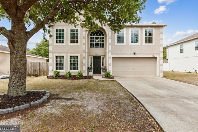 224 Pine Bluff Dr, Kingsland, GA 31548 - traditional-style house featuring fence, an attached garage, driveway, and stucco siding