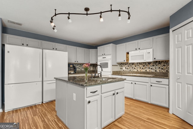 224 Pine Bluff Dr, Kingsland, GA 31548 - kitchen featuring white appliances, light wood-type flooring, a sink, and tasteful backsplash