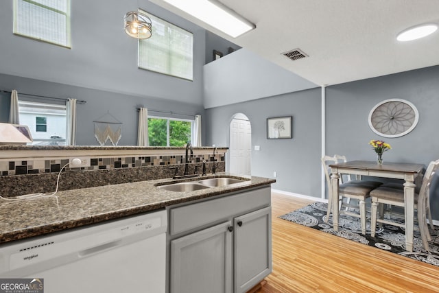 224 Pine Bluff Dr, Kingsland, GA 31548 - kitchen with visible vents, white dishwasher, arched walkways, a sink, and light wood finished floors