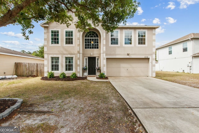 224 Pine Bluff Dr, Kingsland, GA 31548 - traditional home featuring a garage, stucco siding, driveway, and fence