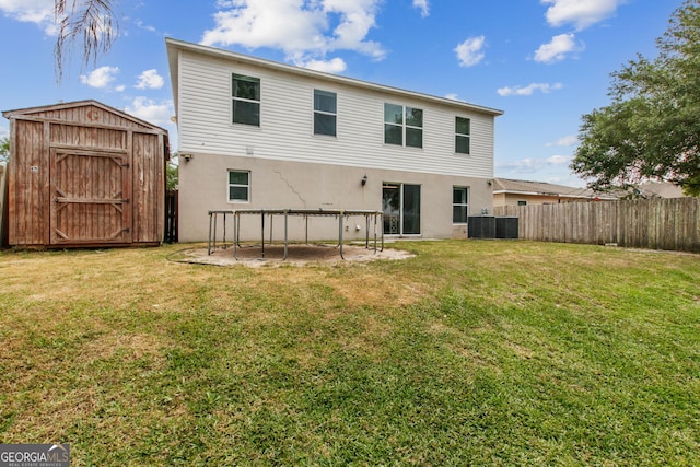 224 Pine Bluff Dr, Kingsland, GA 31548 - back of property featuring stucco siding, an outbuilding, a fenced backyard, and a storage unit