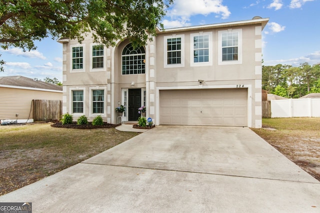 224 Pine Bluff Dr, Kingsland, GA 31548 - view of front of house featuring a garage, concrete driveway, stucco siding, and fence