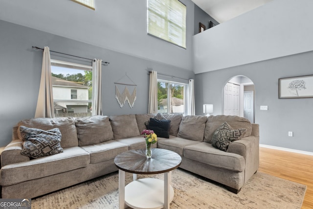 224 Pine Bluff Dr, Kingsland, GA 31548 - living area featuring baseboards, arched walkways, a towering ceiling, and wood finished floors