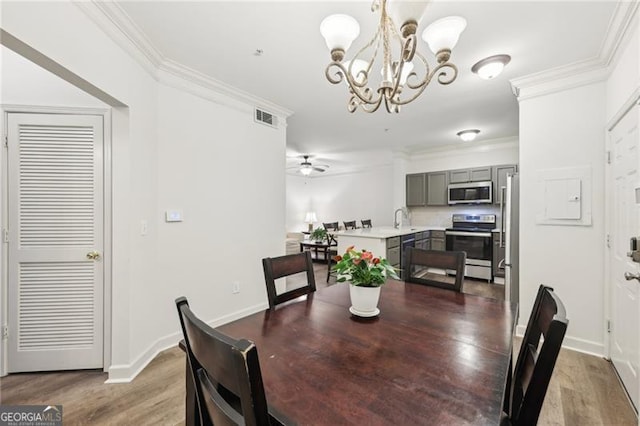 5559 Glenridge Dr Unit 1103, Sandy Springs, GA 30342 - dining space with visible vents, baseboards, ceiling fan with notable chandelier, ornamental molding, and light wood-style flooring