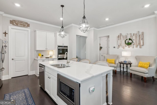 4207 N Carver Dr, Atlanta, GA 30360 - kitchen featuring appliances with stainless steel finishes, light countertops, dark wood-style floors, a center island with sink, and crown molding