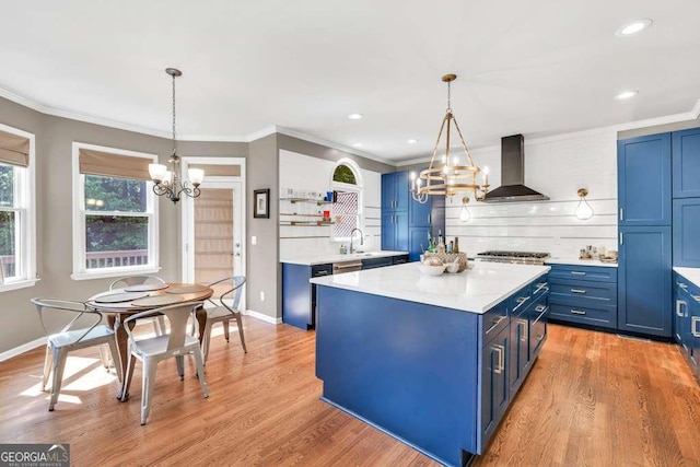 kitchen with open shelves, an inviting chandelier, a sink, range hood, and blue cabinets