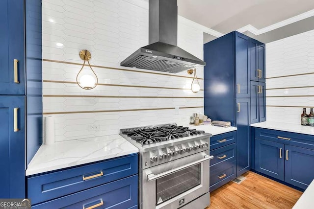 kitchen featuring blue cabinetry, high end stainless steel range oven, crown molding, tasteful backsplash, and wall chimney exhaust hood