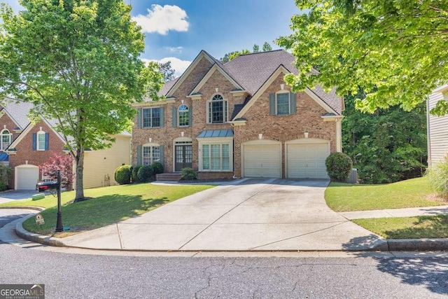 view of front of house featuring brick siding, driveway, and a front yard
