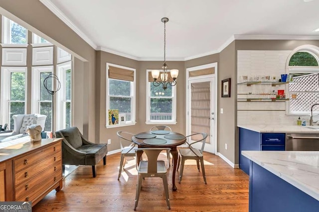 dining area featuring an inviting chandelier, baseboards, ornamental molding, and wood finished floors