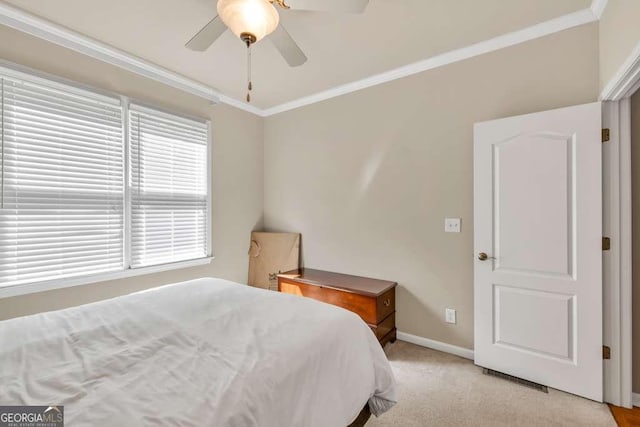 bedroom featuring ceiling fan, visible vents, crown molding, baseboards, and light carpet