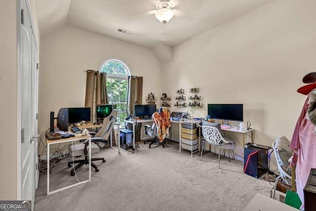 office space featuring carpet floors, a ceiling fan, vaulted ceiling, and visible vents
