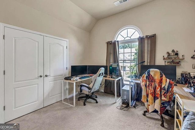 carpeted office space with visible vents and lofted ceiling