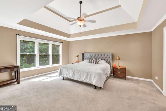 bedroom featuring crown molding, a tray ceiling, and light carpet