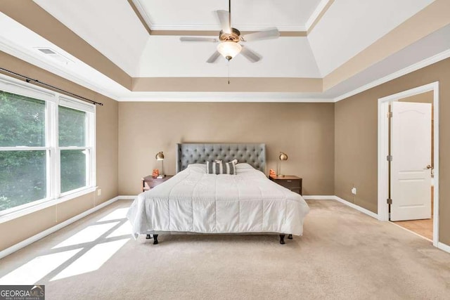 carpeted bedroom featuring ornamental molding, a raised ceiling, and multiple windows