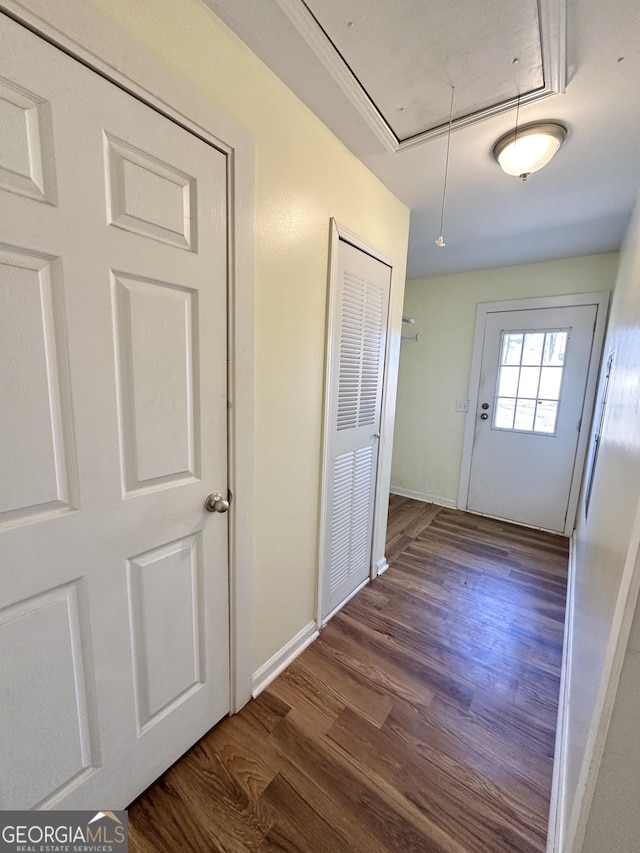 interior space with baseboards, wood finished floors, and attic access