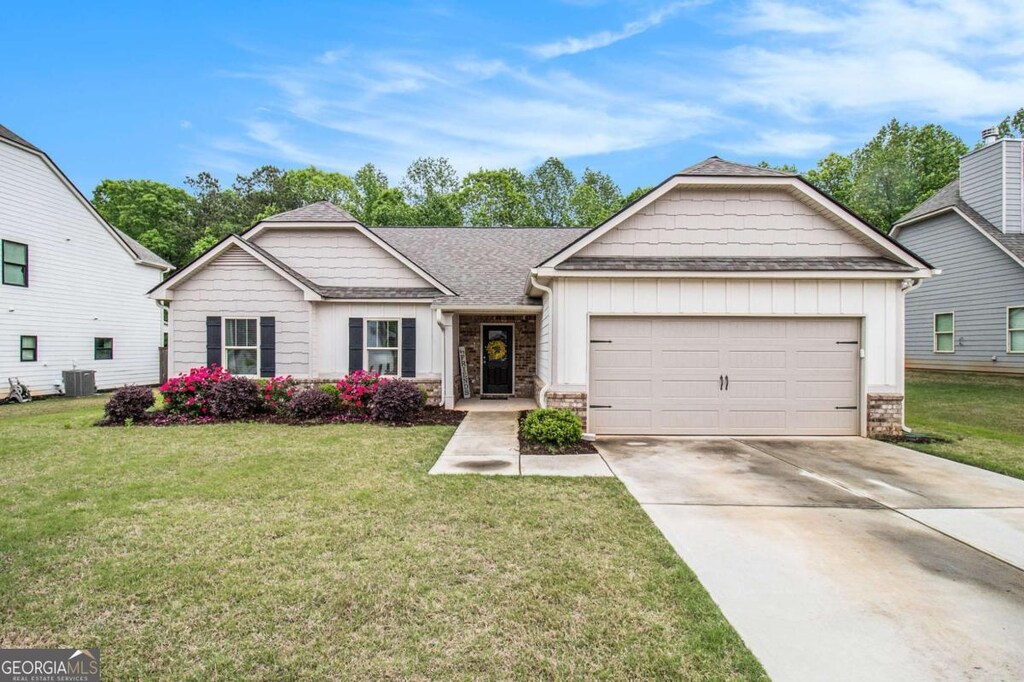 3383 Kottayam Ct, Statham, GA 30666 - view of front of property featuring board and batten siding, an attached garage, driveway, and a front yard