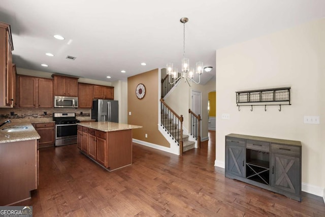 3940 Village Estates Ct, Cumming, GA 30040 - kitchen featuring appliances with stainless steel finishes, a center island, dark wood-style floors, light stone countertops, and recessed lighting